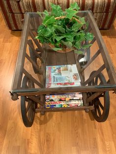 a glass table with magazines and a plant on it in front of a couch or chair