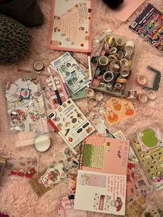 the contents of an assortment of crafting supplies laid out on a pink blanket with scissors, tape and other items