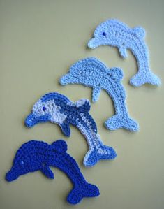 four crocheted dolphins sitting on top of a table