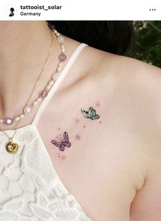 a woman's chest with two butterflies on the left side of her shoulder and one butterfly on the right