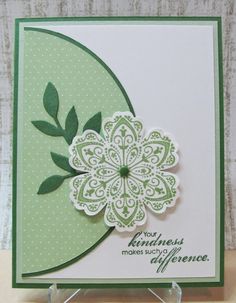 a green and white card with a flower on it