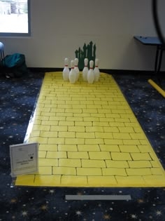 bowling pins on the ground in front of a yellow mat