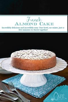 a cake sitting on top of a white cake plate next to silverware and forks