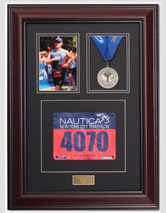 the new york city marathon medal is framed in a black frame with two photos and a blue ribbon