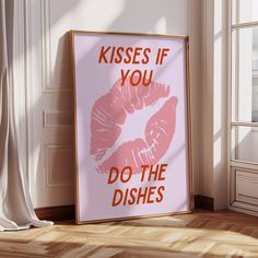 a pink poster with the words kisses if you do the dishes on it in front of a window