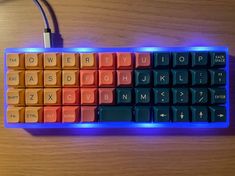 a computer keyboard with an illuminated key board on top of the keyboard is glowing orange and blue