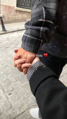 two people holding hands with the words i love you