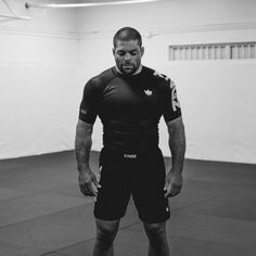 a man is standing in the middle of a gym with his hands on his hips