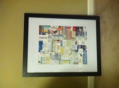 a black frame holding a white and yellow collage with newspaper clippings on it