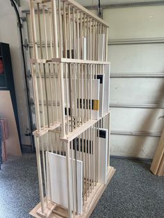 a wooden shelf with several pieces of art on it in front of a garage door