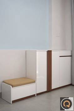 an empty room with some white cabinets and a brown cushion on the seat next to it