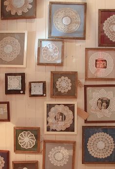 many framed pictures are hung on the wall with lace doily and paper doilies