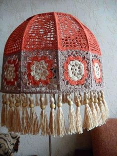 an orange lamp shade with tassels and beads