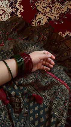 a woman laying on top of a bed covered in lots of different types of bracelets