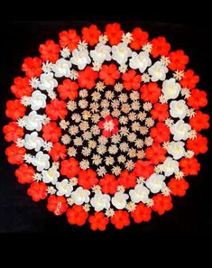 an overhead view of a red and white flower arrangement on a black background with space for text