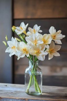 a vase filled with white flowers on top of a wooden table