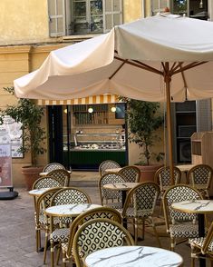 tables and chairs with umbrellas on the sidewalk