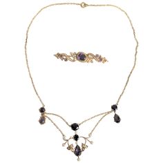 This antique pairing of a yellow 14-karat gold necklace and brooch are presumed to have been made in the United States in circa 1910 in the period Edwardian style. Both pieces are composed of 14-karat yellow gold, amethyst prong set stones and accented with seed pearls. The necklace is done in a spray of prong and bezel set cabochon and marquis cut amethyst stones with small gold flowers accented with seed pearls. The brooch features one central prong set amethyst stone, surrounded by seed pearls and accented by gold swirls on either side accented with seed pearls. Both pieces are clearly marked "14k" on the back. Bezel Set Cabochon, Seed Necklace, Edwardian Fashion, Seed Pearl, Amethyst Stone, Gold Flowers, Pandora Charm Bracelet, Prong Setting, Pearl Necklace