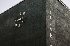 the corner of a building with writing on it and a clock tower in the background