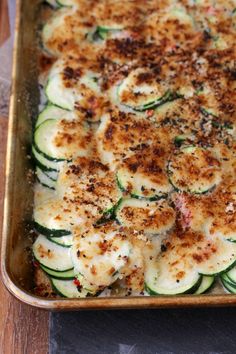 a casserole dish with zucchini and parmesan cheese