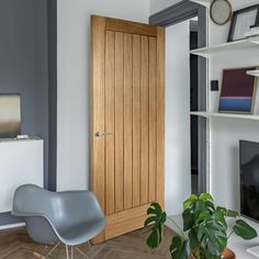 a living room with a chair, television and bookshelf on the wall in front of it