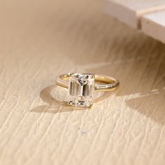 an engagement ring sitting on top of a wooden table