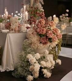 a table topped with lots of white and pink flowers