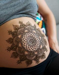 a pregnant woman's belly with an intricate design on it