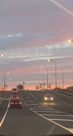 cars are driving down the highway at dusk