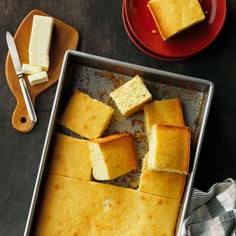 several pieces of cake sitting on top of a pan next to a knife and fork