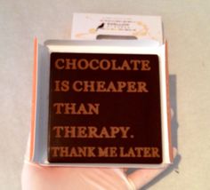 a person's hand holding a chocolate box with the words chocolate is cheaper than therapy thank me later