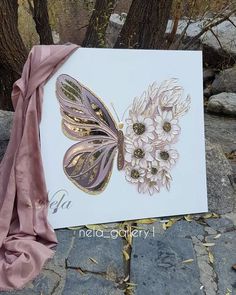 a greeting card with an image of a butterfly and flowers on it, next to a pink scarf