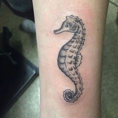 a small seahorse tattoo on the arm