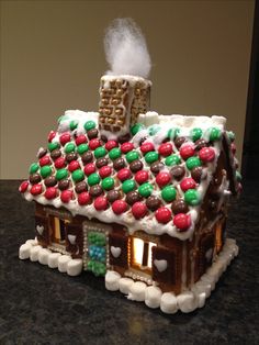 a gingerbread house decorated with candy and marshmallows for the holiday season