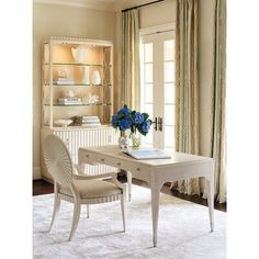 a white desk and chair in front of a window with blue flowers on top of it