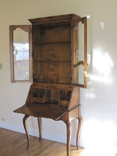 an old wooden desk with a mirror on it's side and a drawer in the middle