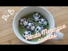 panda meringue cookies are in a mug with green liquid and panda bears on top