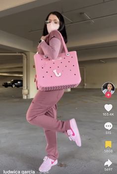 a woman in pink holding a pink purse