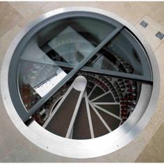 an overhead view of a circular window with glass and metal bars on the bottom floor