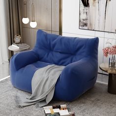 a blue chair sitting in a living room next to a table