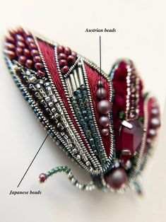 the parts of a beaded butterfly on a white surface with text describing it's features