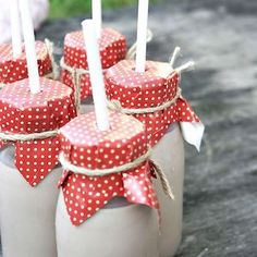 some little jars with candles in them on the ground