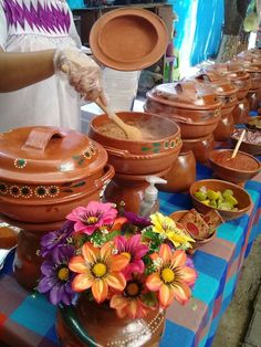 a table topped with lots of pots and pans filled with different types of flowers