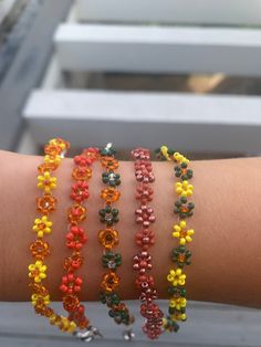 a person's arm with four bracelets on top of it and one is made out of beads