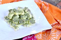 a white plate topped with broccoli florets on top of a table