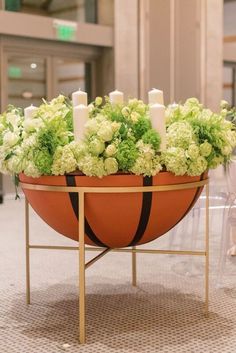 a planter filled with candles and flowers on top of a table in a lobby