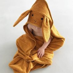 a baby wrapped in a towel with a stuffed animal on it