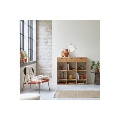 a living room with a chair, table and bookshelf next to a window