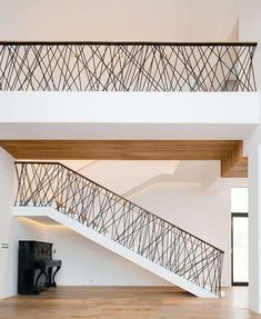 a stair case in the middle of a room with wood flooring and white walls