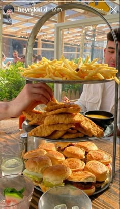 two tiered trays filled with sandwiches and french fries